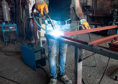 Herrero utilizando maquina para soldar en estructura de acero