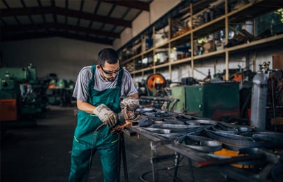 Trabajador realizando una actividad correspondiente a la herrería en su taller