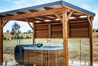 Pergola de madera y acero cubriendo una bañera