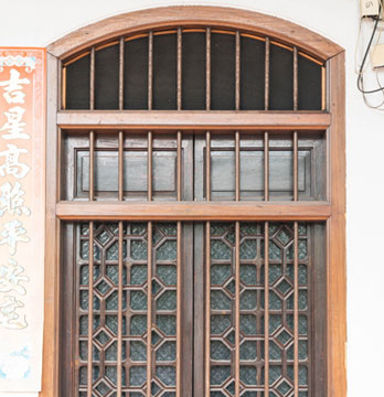 Protección de herrería con arco fabricada en madera y acero instalada sobre la ventana de una casa