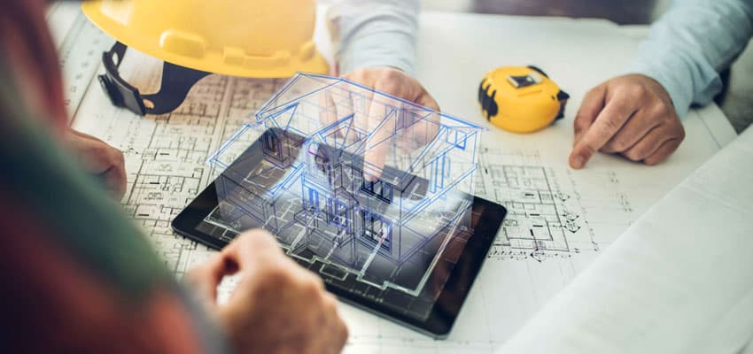 Dos personas observando los planos de una construcción en tercera dimensión, del costado derecho se encuentra una cinta métrica y a la derecha un casco de construcción